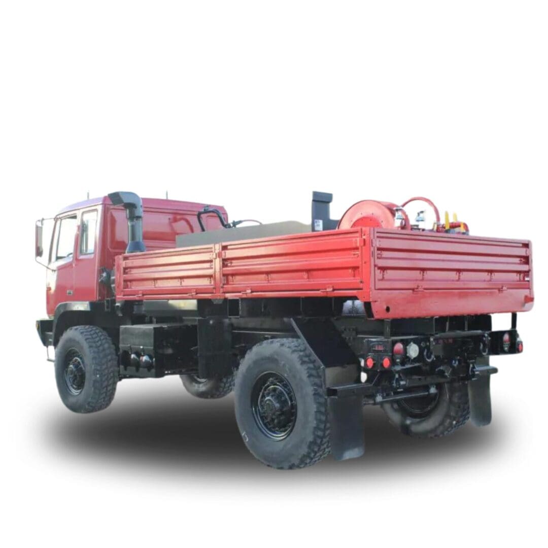 Red truck with flatbed and large tires.